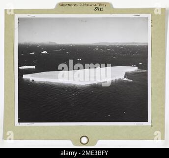 WESTWIND dans la baie Melville. États-Unis Le brise-glace DE la Garde côtière, WESTWIND, dans la baie Melville, au Groenland, approche de cet iceberg tabulaire, le plus grand berg rencontré lors de la mission d'approvisionnement de 1955 dans les stations météorologiques et les bases de l'extrême nord de l'Arctique. Nageant le WESTWIND de 269 pieds, l'iceberg mesure environ 3/4 de long de mille, 1/2 de large, et montre 80 pieds au-dessus de l'eau. Sous la surface, la coque menaçante s'étend sur 560 pieds. Banque D'Images