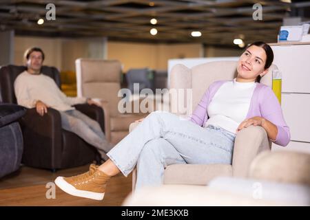 le couple choisit un fauteuil confortable dans le magasin de meubles Banque D'Images