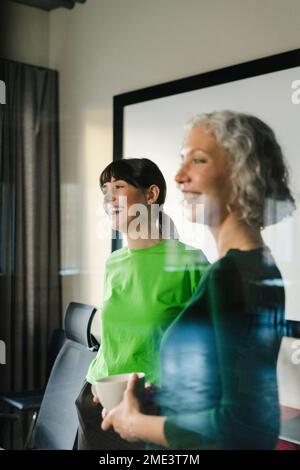 Deux collègues heureux en vêtements verts au bureau Banque D'Images