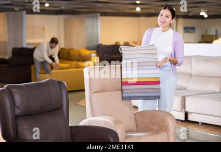 Portrait d'une femme présentant des échantillons de tissus d'ameublement Banque D'Images