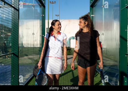 Des amies joyeuses se tenant sur le terrain de sport par beau temps Banque D'Images
