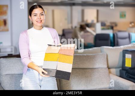 Portrait d'une femme présentant des échantillons de tissus d'ameublement Banque D'Images