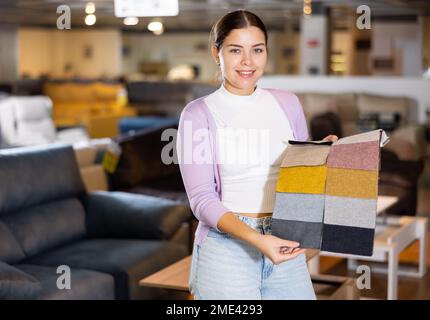 Portrait d'une femme présentant des échantillons de tissus d'ameublement Banque D'Images