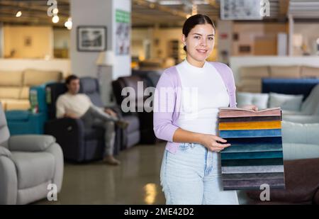 Portrait d'une femme présentant des échantillons de tissus d'ameublement Banque D'Images