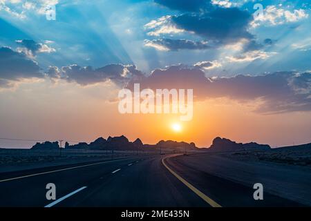 Arabie Saoudite, Al-Ula, soleil se plaçant sur une autoroute vide Banque D'Images