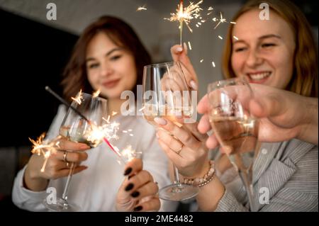 Des amis heureux fêtant avec des verres de champagne et des spamerons à la maison Banque D'Images