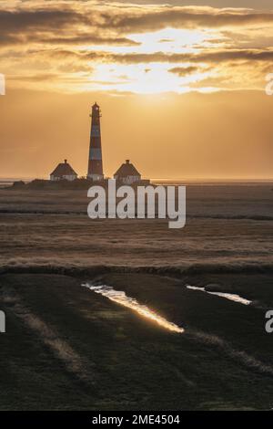 Allemagne, Schleswig-Holstein, St Peter-Ording, phare de Westerheversand au coucher du soleil Banque D'Images