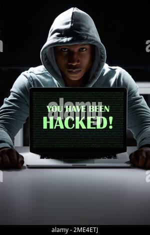 Méfiez-vous des dangers de la cybercriminalité. Un jeune hacker utilisant un ordinateur portable avec les mots que vous avez été piraté dessus. Banque D'Images