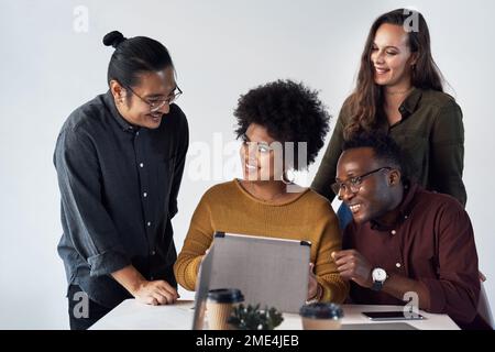 Travailler ensemble crée le succès. un groupe diversifié de professionnels travaillant sur une tablette au bureau. Banque D'Images