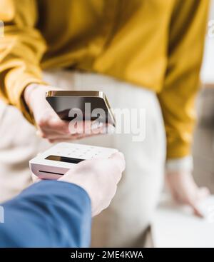 Femme d'affaires payant par téléphone intelligent sur lecteur de carte de crédit Banque D'Images