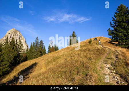 Homme randonnée en montagne à travers un sentier étroit sous le ciel bleu Banque D'Images