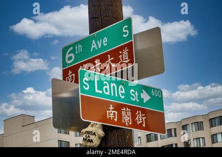 Panneaux de rue en langue double à l'extérieur du village japonais Uwajimaya avec marché asiatique et appartements dans le quartier international de Seattle, Washington. Banque D'Images