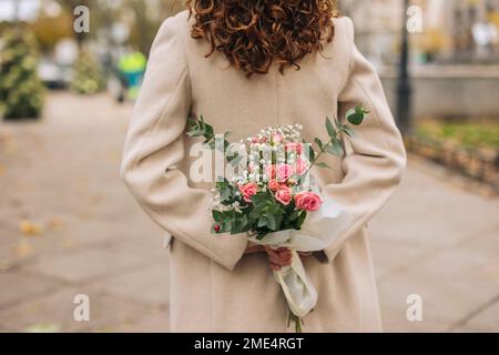 Jeune femme tenant un bouquet de fleurs sur le sentier Banque D'Images