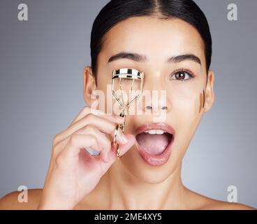 Wow, visage et femme avec fard à paupières en studio isolé sur un fond gris. Portrait, maquillage surprise et cosmétiques de modèle féminin avec outil ou Banque D'Images