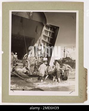 La Garde côtière fait sortir des blessés de Wakde. Les envahisseurs américains, qui ont été abattus par les tireurs de Jap dans le cadre de la conquête rapide mais amèrement combattue de l'île de Wakde au large de la côte nord-hollandaise de la Nouvelle-Guinée sur 18 mai, ont été blessés par les mâchoires massives d'un LST habité par la Garde côtière. Des gardes-côtes sont montrés en train de retirer des blessés sur la plage de Hollandia, à 200 milles à l'est, après avoir participé aux attaques sur Wakde et Sarmi. Leur capture a apporté des bandes d'air importantes aux mains des alliés. Banque D'Images