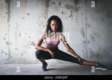 Étirez-vous bien au-delà de vos limites. Photo d'un jeune sportif attrayant qui s'étire tout en s'exerçant à l'intérieur d'un parking souterrain. Banque D'Images