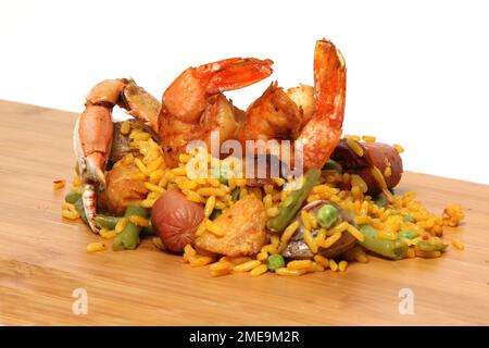 Riz à la paella servi sur une planche de bois avec un saupoudreuse de sel et des fourchettes préparées avec des fruits de mer, des marrons, du safran, des saucisses et de la viande. Plat traditionnel de Valenci Banque D'Images