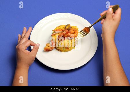 Le riz paella est une recette traditionnelle de la ville de Valence Espagne préparée avec du safran, des fruits de mer, des crevettes, des légumes servis sur une assiette blanche Banque D'Images