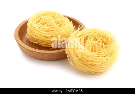 Assiette avec pâtes brutes emboîtées sur fond blanc Banque D'Images