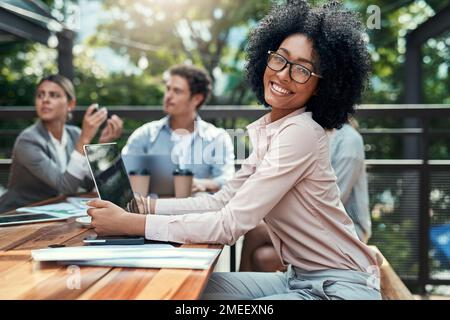 Être ici nous donne une nouvelle perspective sur les affaires. Portrait d'une jeune femme d'affaires ayant une réunion avec ses collègues dans un café. Banque D'Images