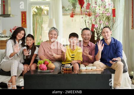 Bonne grande famille ayant du thé et des fruits frais à la maison lors de la fête de Tet Banque D'Images