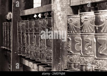 Image en noir et blanc avec point de fuite sur de grandes roues de prière dans un monastère tibétain, Xining, Chine Banque D'Images