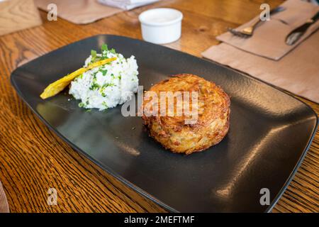 draniki aux pommes de terre et sauce à la crème sure blanche sur une assiette. beignets de légumes crêpes végétariennes repas frais. en-cas sur le fond de la nourriture de table. Banque D'Images