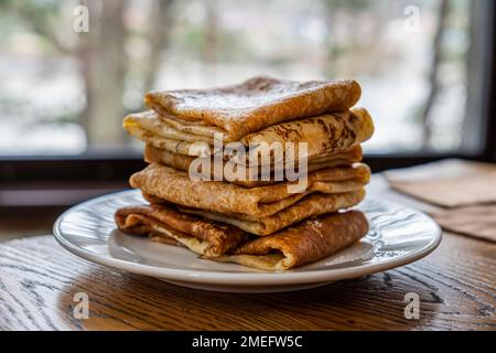 beaucoup de crêpes sur une assiette sur la table contre le fond d'un oeil avec une vue de la nature. Semaine de Shrovetide. Banque D'Images