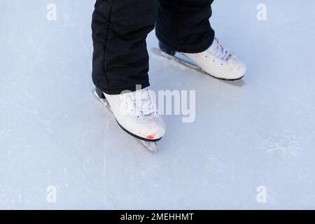 Une paire de patins de hockey avec lacets sur la patinoire surgelée en gros plan.Patinage sur glace ou hockey en hiver. Glace et jambes et espace de copie au-dessus du backgroun de glace Banque D'Images
