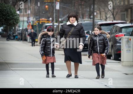 Une mère et 2 filles qui sont vêtues de la même façon, probablement parce que les jupes sont des uniformes d'école. À Brooklyn, New York. Banque D'Images