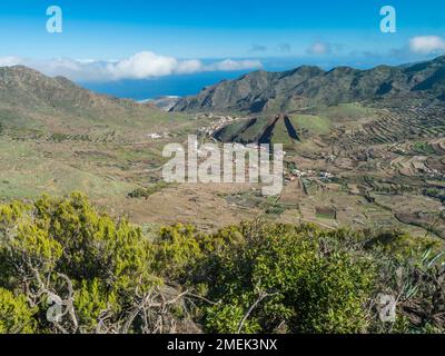 Vallée verdoyante avec champs en terrasse et village Las Portelas. Paysage avec des rochers et des collines vues depuis le sentier de randonnée au parc rural de Teno, Tenerife Banque D'Images