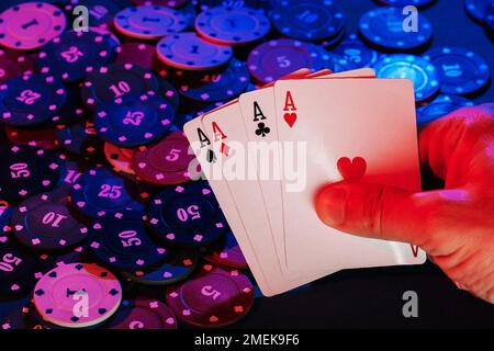 les mains des hommes tiennent des cartes , mettez des as sur l'arrière-plan des jetons de jeu Banque D'Images