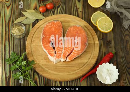 Steak de saumon frais avec ingrédients sur fond de bois sombre Banque D'Images