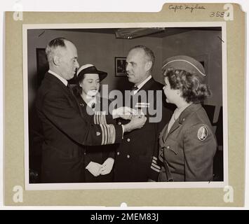 Le capitaine Frank D. Higbee reçoit la Médaille de la Légion du mérite pour son leadership en tant que commandant d'un groupe de LTS lors d'assauts amphibies en Nouvelle-Guinée. La médaille est remise par le vice-amiral Russell R. Waesche au quartier général de la Garde côtière américaine à Washington Banque D'Images