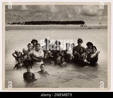 Les gardes-côtes et les indigènes de Tarawa posent pour la photo. ÉTATS-UNIS Les gardes-côtes et les indigènes de l'atoll de Tarawa, qui montrent aux gardes-côtes l'emplacement d'un récif, posent pour un photographe de combat de la Garde côtière. Les autochtones sont tous des sourires. Les gardes-côtes ont participé à l'invasion en tant que membres d'un groupe de travail de la Marine. Banque D'Images