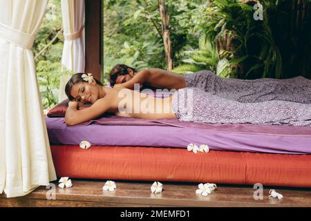 Photo d'une jeune femme et d'un homme allongé sur une table de massage au spa de jour. Couple dans un complexe de luxe. Banque D'Images