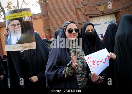 Téhéran, Téhéran, Iran. 24th janvier 2023. Des étudiantes iraniennes voilées dans des chadors noirs portant l'uniforme du corps des Gardiens de la révolution islamique (IRGC), portant un écriteau écrit ''Je suis l'une des forces du corps des Gardiens de la révolution islamique (IRGC)'' et une bannière du portrait du dirigeant iranien, l'ayatollah Ali Khamenei, Se rassembler pour protester après que Charlie Hebdo ait publié des caricatures du dirigeant suprême de l'Iran, Ali Khamenei, devant l'ambassade de France à Téhéran, en Iran, sur 24 janvier 2023. Crédit : ZUMA Press, Inc./Alay Live News Banque D'Images