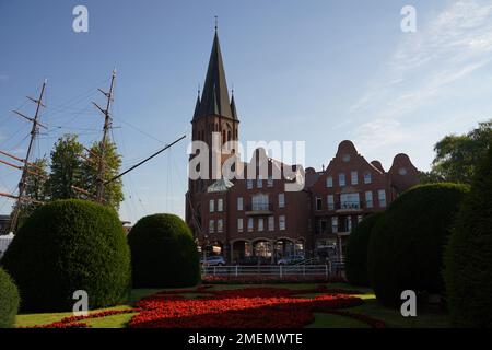 Jardin avec arbres taillés devant une maison de conte de fées Banque D'Images