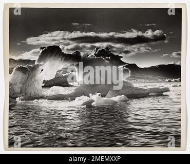 Un iceberg, proche de son point de désintégration, flotte sur une mer arctique calme, incarnant le danger et la beauté des éléments glacés. La patrouille internationale des glaces de la Garde côtière américaine a contribué à réduire le risque de collision d’icebergs avec des navires en surveillant et en suivant ceux-ci à travers l’Atlantique. Banque D'Images