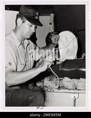 Le garde-côtes Robert F. Dienert, parachute Rigger de 2e classe de San Antonio, Texas, prépare des rations de survie et de l'eau pour le largage aérien aux occupants d'un croiseur de 23 pieds coincé dans l'Atlantique. La Garde côtière a largué des fournitures, y compris de la nourriture, de l'eau, du café et une radio portative pour soutenir les quatre passagers jusqu'à ce qu'un patrouilleur arrive pour effectuer l'opération de sauvetage. Banque D'Images