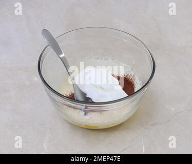 Placer les blancs d'œufs sur le mélange de cacao et de jaune, faire de la roulade de noix de Chestnut au chocolat Banque D'Images