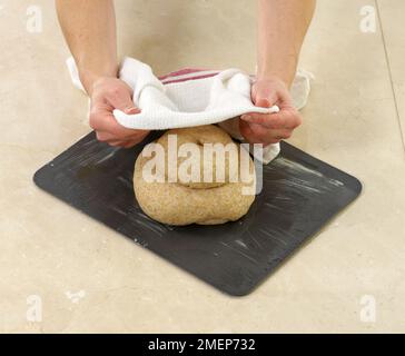 Pain cottage complet, couvrant le pain avec une serviette de thé jusqu'à ce qu'il double Banque D'Images