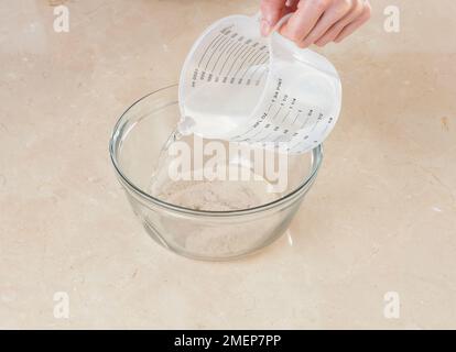 Faire une entrée pour le pain de levain, dissoudre la levure dans de l'eau tiède Banque D'Images