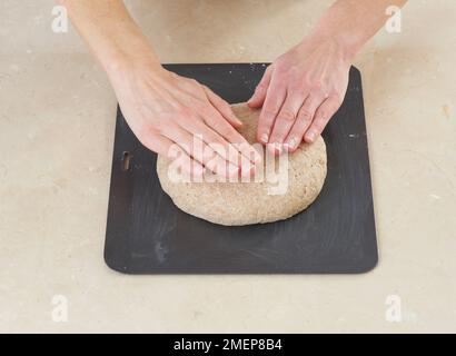 Faire du pain soda, mettre le pain sur la plaque de cuisson et le patronner en un rond Banque D'Images