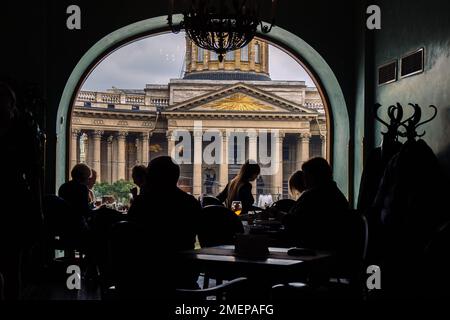 Vue sur la cathédrale de Kazan depuis le café Singer par la fenêtre. Silhouettes de personnes assises à des tables dans l'ancienne maison de la chanteuse à Saint-Pétersbourg, Russie. Photo de haute qualité Banque D'Images