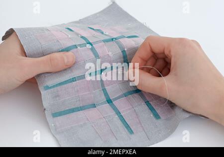 Coutures à la main des perles de semence sur des rubans tissés pour les maintenir ensemble, gros plan Banque D'Images