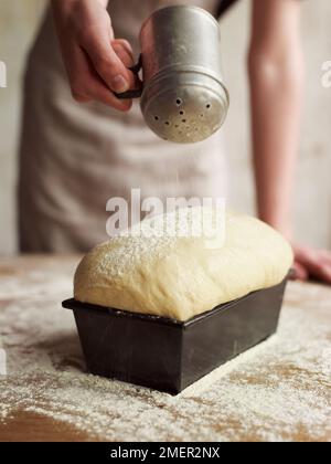 Saupoudrer la pâte à pain avec la farine augmenté Banque D'Images