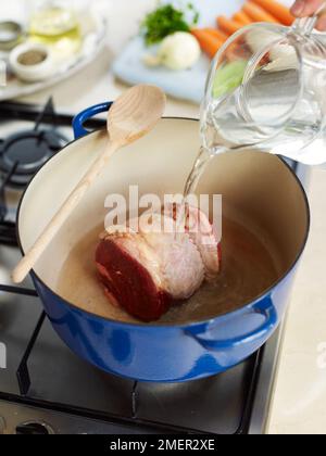 Verser de l'eau sur la poitrine de bœuf dans la casserole (faire du pot-au-feu) Banque D'Images