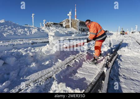 Schierke, Allemagne. 24th janvier 2023. Un employé du chemin de fer à voie étroite Harz déneige les voies de la gare de Brocken. Le sommet du Brocken se présente en hiver. Soleil éclatant et à peine aucun vent à des températures autour de moins 2 degrés il y avait sur le Brocken. Credit: Matthias Bein/dpa/Alay Live News Banque D'Images