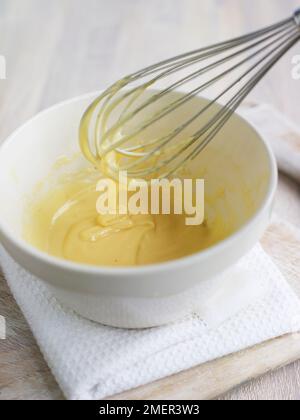 Mayonnaise dans un bol et égouttement du fouet métallique Banque D'Images